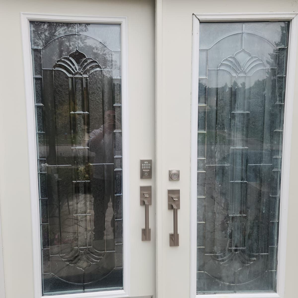 Double front doors with art deco leaded glass inserts featuring elegant arched design