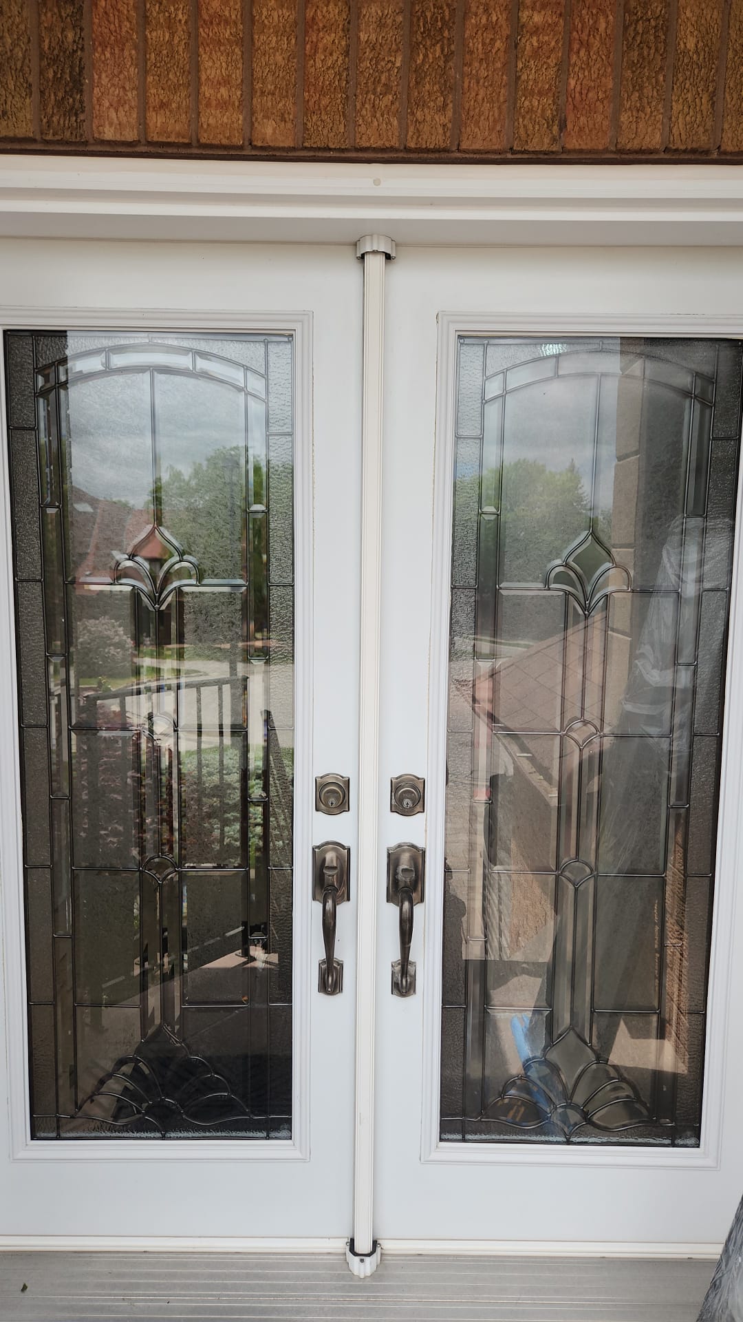 Double front entry doors with traditional leaded glass inserts before replacement