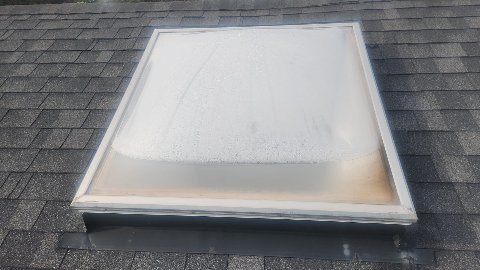 Old foggy acrylic skylight dome on a Richmond Hill roof before replacement
