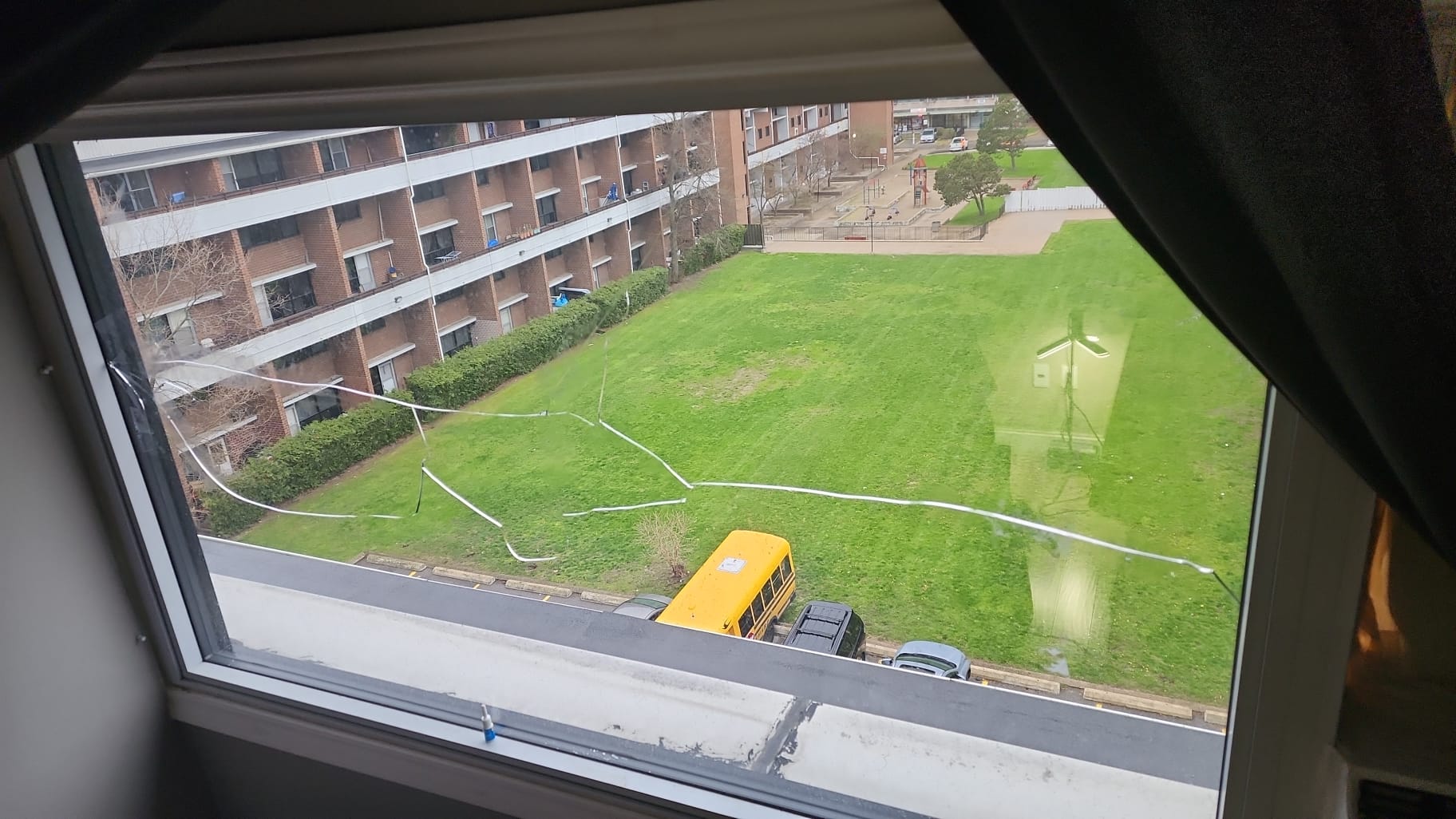 Dirty high-rise window with heavy streaks and grime obscuring the view